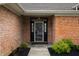 Inviting front entrance features a storm door, manicured shrubs, and a walkway leading to the home at 2813 W Long Meadow Ln, Muncie, IN 47304