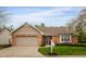 Charming brick home featuring an attached garage, well-manicured lawn, and blossoming trees at 2813 W Long Meadow Ln, Muncie, IN 47304