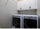 Bright laundry room with front-load washer and dryer, and white cabinets for storage, perfect for convenience at 2813 W Long Meadow Ln, Muncie, IN 47304