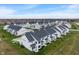 An aerial shot showing rows of townhomes, each with well-maintained lawns, driveways, and a cohesive architectural style at 3240 Arabian Ln, Zionsville, IN 46077