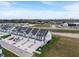 A scenic view of the community features townhomes, each with driveways, garages, and landscaping, set against a backdrop of greenery at 3240 Arabian Ln, Zionsville, IN 46077