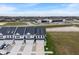 A drone shot shows a community of modern townhomes with manicured lawns, private driveways, and a serene pond nearby at 3240 Arabian Ln, Zionsville, IN 46077