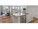 Open-concept living space features a kitchen island with stainless steel appliances and a sink at 3240 Arabian Ln, Zionsville, IN 46077