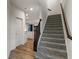 Staircase with grey carpeting and dark wood railing leading to the second floor at 3240 Arabian Ln, Zionsville, IN 46077