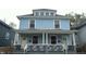 Two-story home featuring a covered front porch with classic white pillars and light blue siding at 3319 N Capitol Ave, Indianapolis, IN 46208