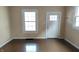 Living room featuring hardwood floor, a window and a white door at 3319 N Capitol Ave, Indianapolis, IN 46208
