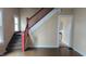 Bright living room featuring wooden stairs with red banister and view to kitchen at 3319 N Capitol Ave, Indianapolis, IN 46208