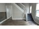 View of the living room with wooden floors, a staircase, and natural light from the windows at 3319 N Capitol Ave, Indianapolis, IN 46208