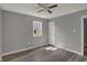 Bedroom featuring neutral walls, a ceiling fan, a window and a white door, and wood-look flooring at 3343 N Drexel Ave, Indianapolis, IN 46218