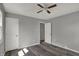 Bedroom featuring neutral walls, a ceiling fan, two white doors, and wood-look flooring at 3343 N Drexel Ave, Indianapolis, IN 46218