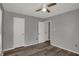 Bedroom featuring neutral walls, a ceiling fan, two white doors, and wood-look flooring at 3343 N Drexel Ave, Indianapolis, IN 46218
