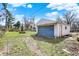 View of detached garage with blue door, set within a green lawn, under a blue sky at 3343 N Drexel Ave, Indianapolis, IN 46218