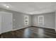 A spacious living room featuring gray walls, wood flooring, and natural light from two windows at 3343 N Drexel Ave, Indianapolis, IN 46218