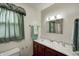 Bathroom with vanity, marble countertop, sink, mirror, and window with green curtain at 3360 E Main St, Danville, IN 46122