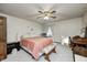A bedroom features a ceiling fan, a bed with a pink coverlet, a desk, and a window with curtains at 3360 E Main St, Danville, IN 46122