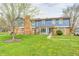 Charming blue two-story townhome with a brick chimney and beautiful green lawn at 3360 E Main St, Danville, IN 46122