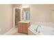 Bathroom featuring vanity, large soaking tub, and view of glass enclosed shower at 355 E Ohio St # 309, Indianapolis, IN 46204