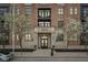 Beautiful brick building with stone accents, flags, flowering trees, and black framed windows at 355 E Ohio St # 309, Indianapolis, IN 46204
