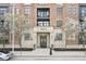 Beautiful brick building with stone accents, flags, flowering trees, and black framed windows at 355 E Ohio St # 309, Indianapolis, IN 46204