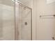 Close up of the glass-enclosed shower featuring neutral toned tile at 355 E Ohio St # 309, Indianapolis, IN 46204