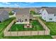 Aerial view of fenced backyard featuring patio with seating, fire pit, and well-manicured lawn at 371 Bluestem Ln, Whiteland, IN 46184