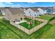 Aerial view of a fenced backyard featuring a patio and a cozy fire pit area at 371 Bluestem Ln, Whiteland, IN 46184