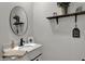 Stylish powder room featuring a round mirror, modern sink and vanity, and decorative elements at 371 Bluestem Ln, Whiteland, IN 46184