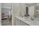 Bathroom featuring double sinks with white cabinetry, quartz countertop, large mirror, and shower with glass door at 371 Bluestem Ln, Whiteland, IN 46184