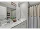 Bathroom featuring double sinks with white cabinetry, quartz countertop, decorative mirror, and shower with curtain at 371 Bluestem Ln, Whiteland, IN 46184