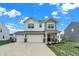 Charming two-story home featuring a spacious three-car garage and manicured lawn at 371 Bluestem Ln, Whiteland, IN 46184