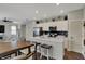 Open kitchen and dining area with island, modern appliances, white cabinetry, and hardwood floors at 371 Bluestem Ln, Whiteland, IN 46184