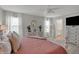 Bright main bedroom featuring a ceiling fan, decorative mirror, patterned bedding, and ensuite bathroom access at 371 Bluestem Ln, Whiteland, IN 46184
