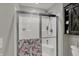 Shower enclosure with glass doors, shower head, storage caddy, and decorative floral towel hanging on the door at 371 Bluestem Ln, Whiteland, IN 46184