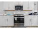 Well-lit kitchen featuring white cabinets, subway tile backsplash, and stainless steel appliances at 3999 Kensington Dr, Danville, IN 46122