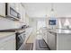 Modern kitchen with white cabinets, stainless steel appliances, and an open layout dining area at 3999 Kensington Dr, Danville, IN 46122