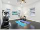 Bright bonus room with exercise machine, yoga mats, and accent chair by sunlit windows at 415 S Oxford St, Indianapolis, IN 46201
