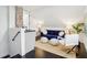 Stylish bonus room with a blue velvet sofa, a mini-bar and white ottomans creating a cozy retreat at 415 S Oxford St, Indianapolis, IN 46201