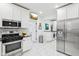 Eat-in kitchen with stainless steel appliances, white cabinets, and a door to the laundry room at 415 S Oxford St, Indianapolis, IN 46201