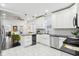 Open-concept kitchen featuring white cabinets, stainless steel appliances, black countertops, and an island at 415 S Oxford St, Indianapolis, IN 46201
