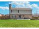 A spacious backyard with brick-and-siding home, wooden fence, and patio with sliding door and a stack of firewood at 4421 Brittany Dr, Zionsville, IN 46077