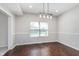 Cozy dining room boasts hardwood floors, wainscoting, and a modern chandelier to create an inviting atmosphere at 4421 Brittany Dr, Zionsville, IN 46077