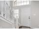 Bright foyer featuring a white staircase and a welcoming front door at 4421 Brittany Dr, Zionsville, IN 46077
