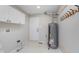 Functional utility room featuring a water heater, storage cabinets, and access to the exterior at 4421 Brittany Dr, Zionsville, IN 46077