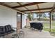 Cozy covered back patio, complete with outdoor seating, a grill, and views of the yard at 443 S Arlington Ave, Indianapolis, IN 46219