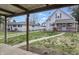 Spacious backyard with a covered patio, walkway, and neighboring home at 443 S Arlington Ave, Indianapolis, IN 46219