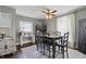 The dining room includes a long table with chairs, a ceiling fan, and plenty of natural light at 443 S Arlington Ave, Indianapolis, IN 46219
