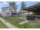 Charming two-story home with a cozy front porch and fenced yard, alongside a covered patio and additional structure at 443 S Arlington Ave, Indianapolis, IN 46219