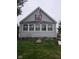 Charming home featuring gray siding, complemented by an American flag, and a well-maintained front lawn at 443 S Arlington Ave, Indianapolis, IN 46219