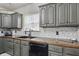Kitchen with dark cabinets, wood countertops, stainless steel appliances, and natural light at 443 S Arlington Ave, Indianapolis, IN 46219