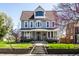 Charming two-story home featuring a inviting front porch, well-manicured lawn, and beautiful architectural details at 4849 Central Ave, Indianapolis, IN 46205